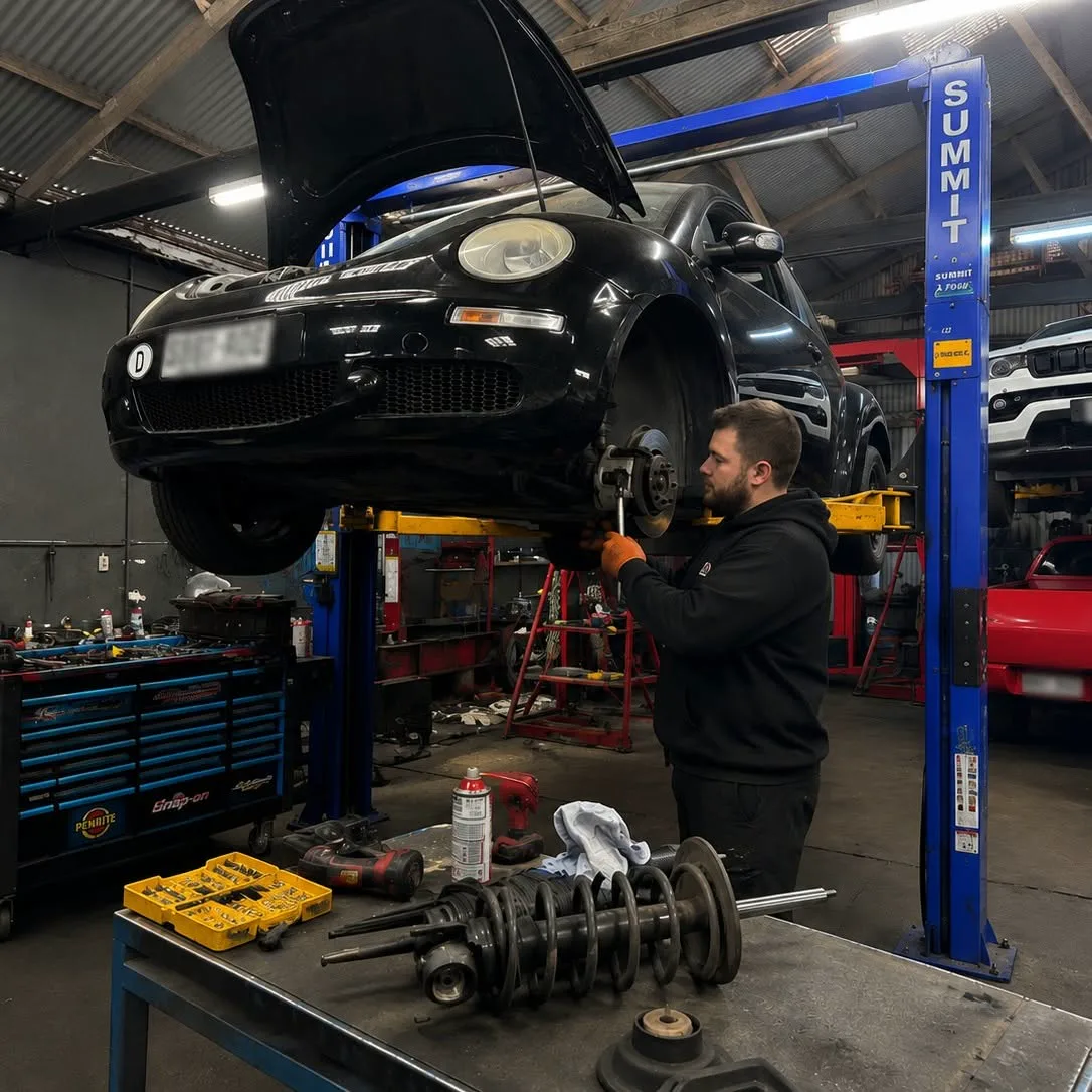Suspension work underway on a vehicle raised on the hoist